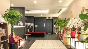 A reception area with a reception desk, a seating area, and potted plants.