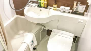 A bathroom with a white sink, toilet, and shower. There are toiletries on the sink and a towel hanging on the wall.