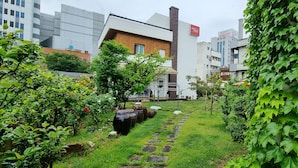 Un jardín con un sendero de piedra, plantas en macetas y una valla de madera.