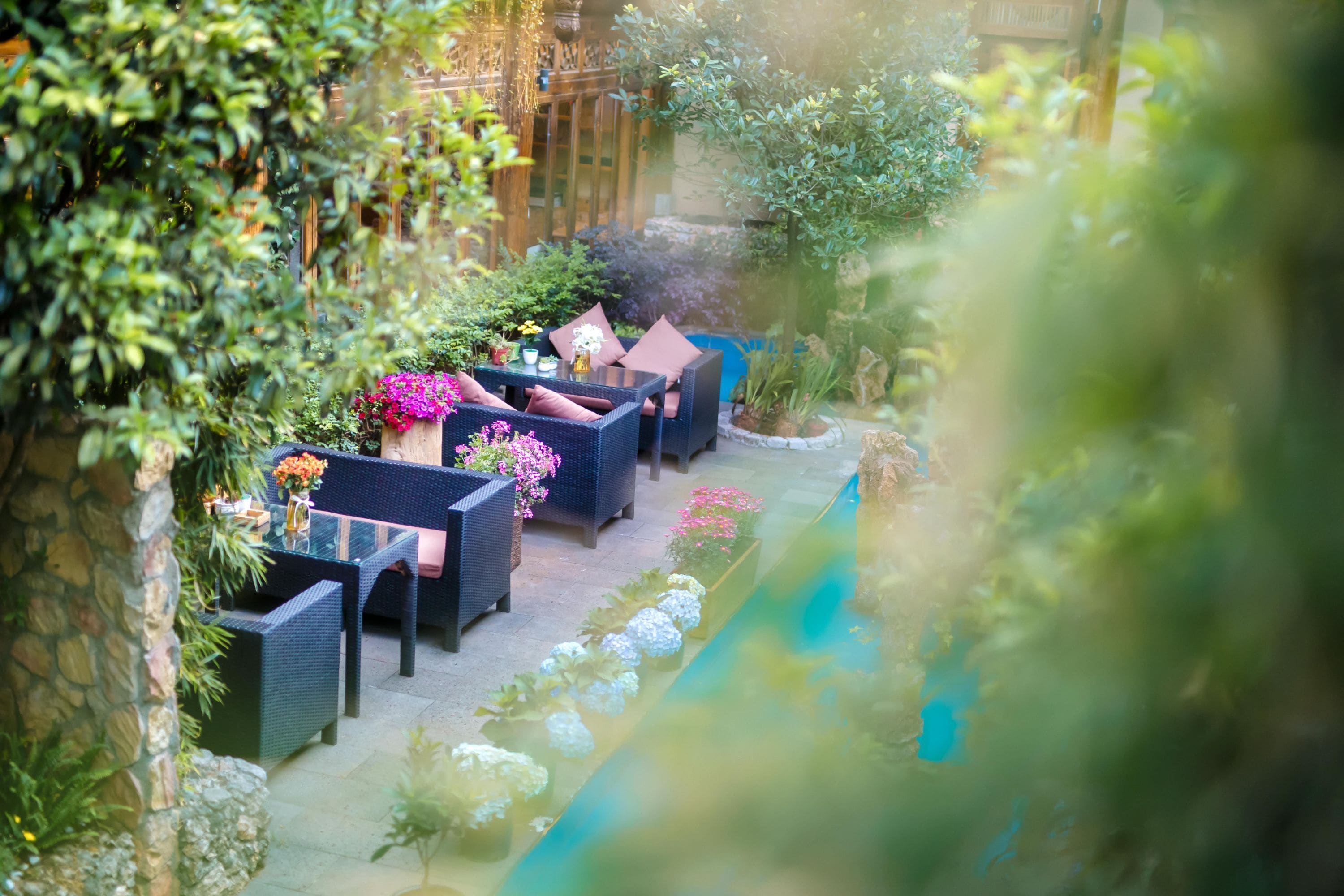An outdoor seating area with wicker furniture and potted plants.