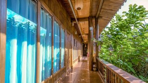 Un couloir en bois doté de grandes fenêtres et d’une rambarde en bois.