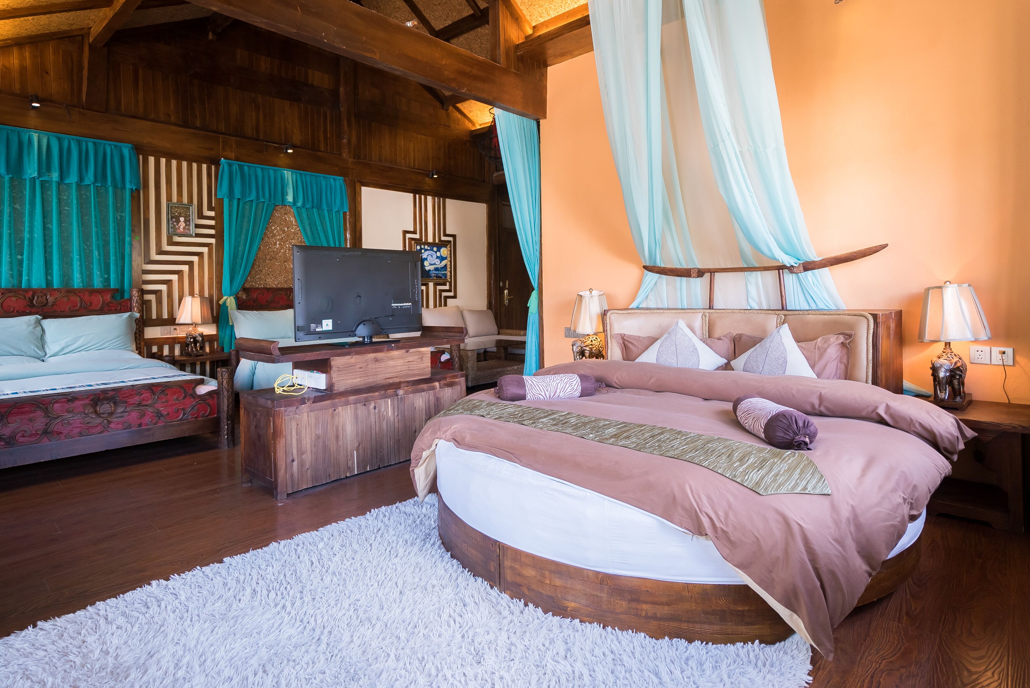 Ein geräumiges Schlafzimmer mit einem großen Bett, einem Fernseher und einem Holztisch.