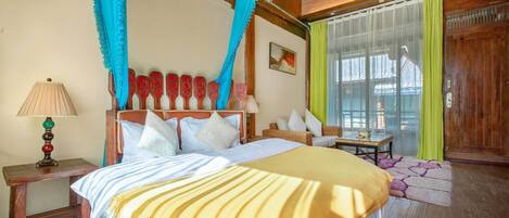 Un dormitorio con cama, mesita de noche, lámpara y cortinas.