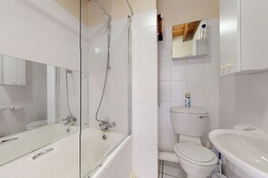 A modern bathroom with a glass-enclosed shower, a white toilet, and a sink.
