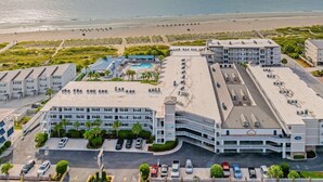 A hotel with multiple buildings, a parking lot, and a beach view. - Summer & July 4th Savings at Beachside Colony Tybee's ONLY Oceanfront Resort 3/2 (Tybee Island)