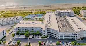 Un hôtel comprenant plusieurs bâtiments, un parking et offrant une vue sur la plage.