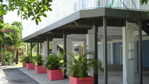 Un espace extérieur abrité, agrémenté de plusieurs jardinières rouges et doté d’un sol en béton.