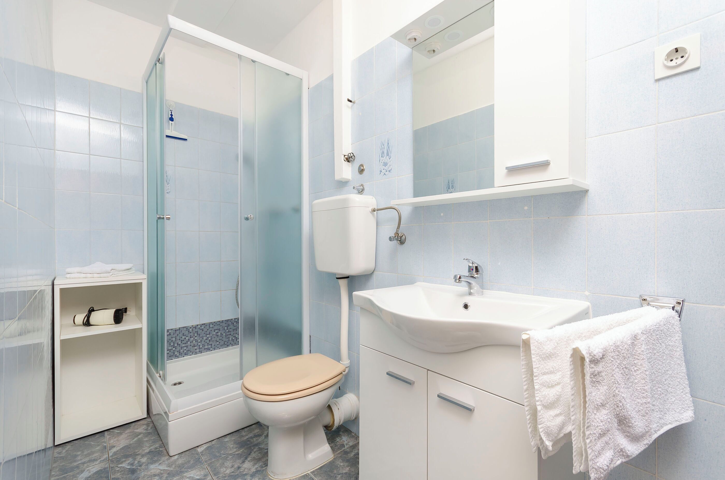 A bathroom with a toilet, sink, and shower.