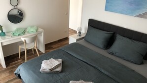 A bedroom with a bed, a desk, and a chair. - Apartments Lumini (Okrug Gornji)