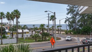 Eine Küstenstraße mit Palmen, einem Strand und einem klaren Himmel.