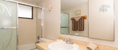 Une salle de bain avec une baignoire, des toilettes, un lavabo et un grand miroir.