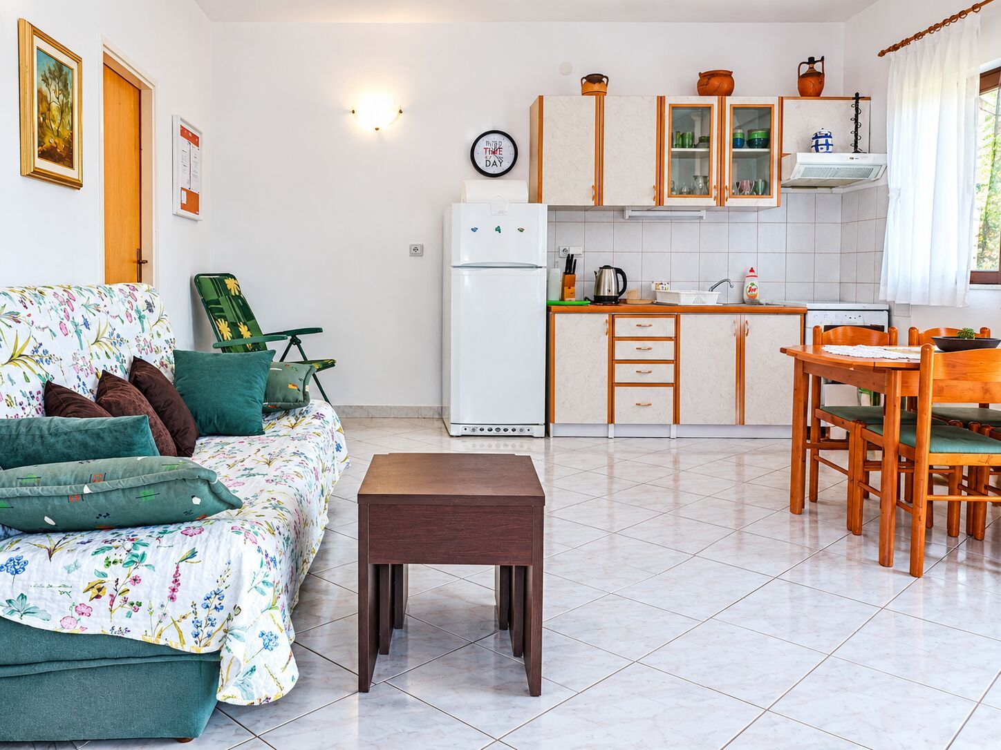 Un espace de vie compact comprenant un canapé, une table à manger et un coin cuisine.