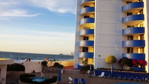 Een hotel met een zwembad, terras en uitzicht op de oceaan.