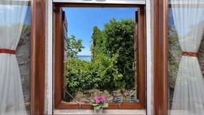 A window with a view of a garden and a stone wall. - House Olive (Tucepi)