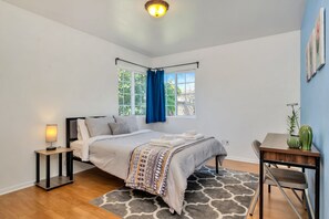 A bedroom with a bed, bedside table, and a window with curtains. - ⭐️offering the Lowest Rate (2000 sqf)-KingBed, Pool Table, 55” Smart TV (Ontario)