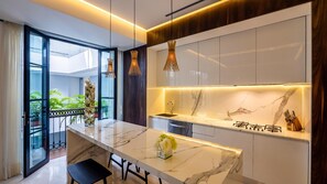 A modern kitchen with a marble countertop, pendant lighting, and a view of greenery outside. - PIER 57 - 510  | 2BR Condo w/ Great Mountain View (Puerto Vallarta)
