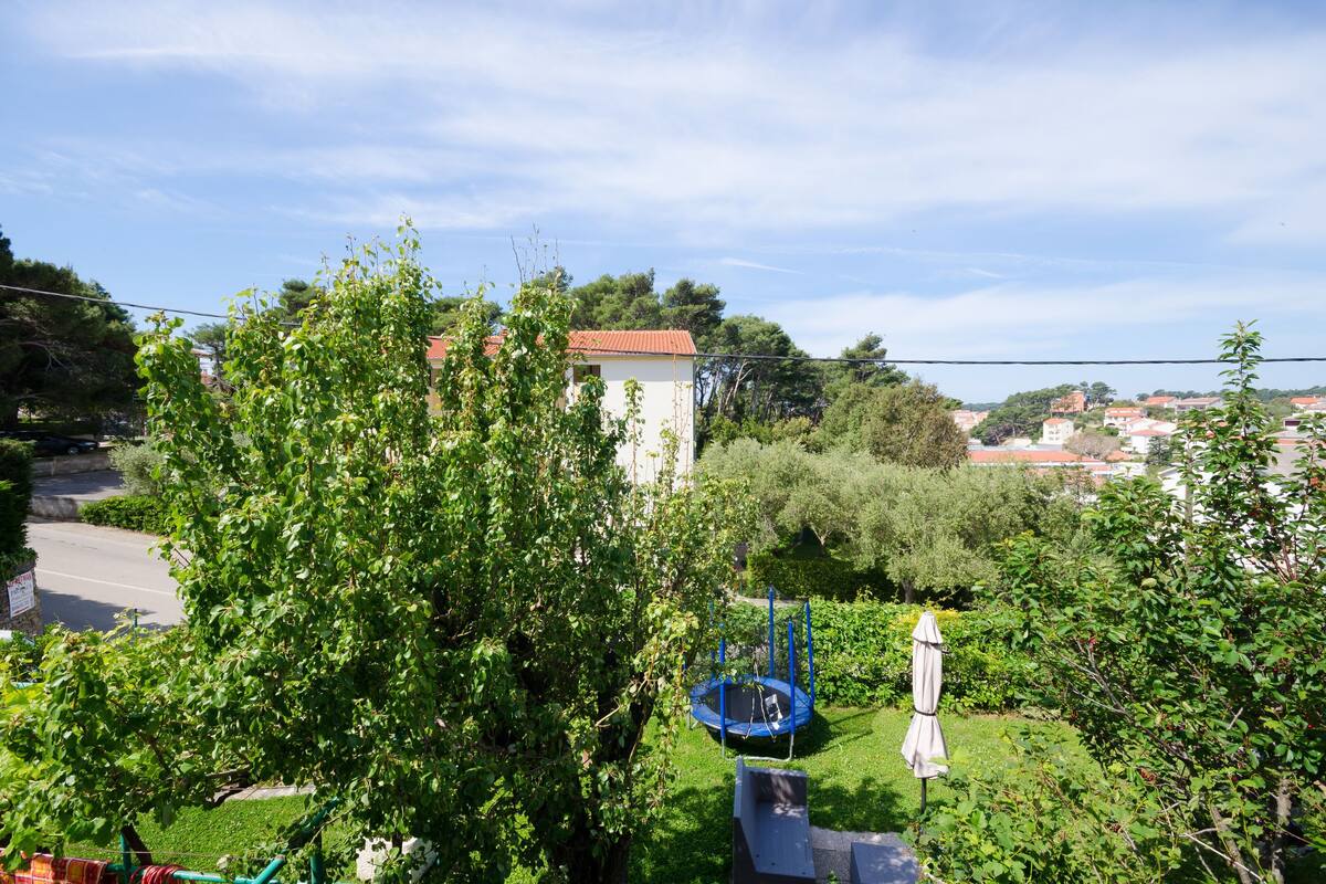 A residential area with a house, a trampoline, and a garden.