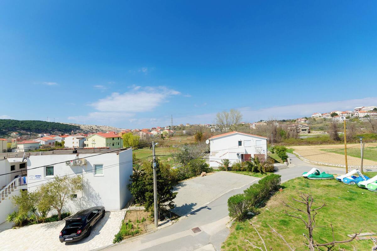 Un quartiere residenziale con case, una strada asfaltata e un'auto parcheggiata.