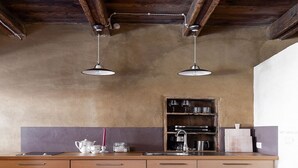 Une cuisine avec des meubles en bois, un évier et des luminaires suspendus.