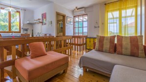 A cozy room with a wooden bench, a bed, and a dining area with a view. - House Haus Vlady (Crikvenica)