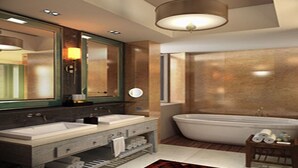 Un baño moderno con un lavamanos grande, una bañera y un espejo.