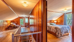 Eine Holzhütte mit Schlafzimmer auf dem Dachboden, einem Essbereich und einer Treppe.