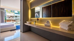 Ein modernes Badezimmer mit großem Spiegel, Waschbecken und Handtuchhalter.