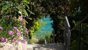Una scala in pietra con ringhiera che conduce a una vista sull'acqua.