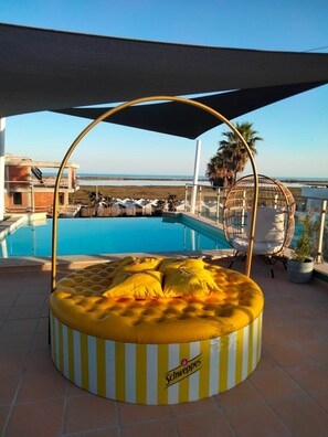 Een buitenzwembad, ligstoelen bij het zwembad