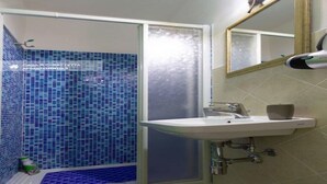 A bathroom with a shower area, a sink, and a mirror. - Patty Studio 'Casa a Chiazzetta' (Castelbuono)