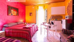 A room with a bed, a desk, a chair, and a kitchenette. - Patty Studio 'Casa a Chiazzetta' (Castelbuono)