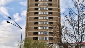 A multi-story residential building with a curved facade, multiple balconies, and a street lamp in the foreground. - Apartment on Ismayil bay Qurtqashinli 50 (Baku)