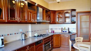 A kitchen with wooden cabinets, a stainless steel range, a dishwasher, and a tiled backsplash. - Apartment on Ismayil bay Qurtqashinli 50 (Baku)