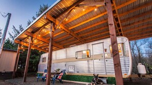 Parque para vehículos recreativos techado, con una autocaravana estacionada bajo una estructura de madera.