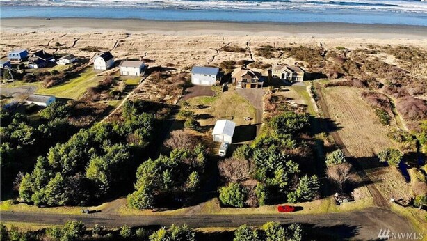 Vista aérea de una zona costera con casas, una carretera y una playa.