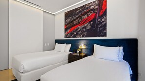 A hotel room with two beds, a nightstand with a lamp, and a large abstract painting on the wall.