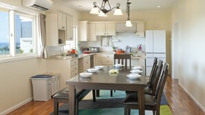 A modern kitchen with white cabinets, a dining table set for six, and a view of the outdoors. - Onnason vacation rental C (Onna)