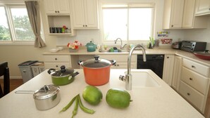 A kitchen with white cabinets, a sink, a stove, and a microwave. - Onnason vacation rental C (Onna)