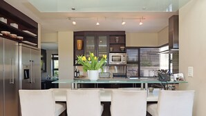A modern kitchen with a central island, bar stools, and a built-in microwave. - Vacation Villa 2WW (Cape Town)