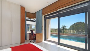 A modern bedroom with a large sliding glass door leading to a pool area. - Vacation Villa 2WW (Cape Town)