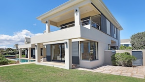 A modern two-story house with a swimming pool, large windows, and a well-maintained lawn. - Vacation Villa 2WW (Cape Town)