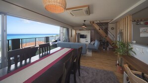 Un vaste espace de vie comprenant une table à manger, un canapé et un escalier menant à l’étage supérieur.
