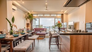 A modern kitchen with a dining area, large windows, and a view of the city. - Onnason vacation rental N (Onna)