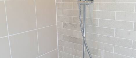 A shower with a handheld showerhead and a flexible hose.