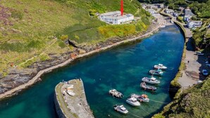A coastal town with a marina, boats, and a prominent lighthouse. - A beautiful harbourside four-bedroom cottage with harbour views (Boscastle)