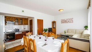 Zona d'estar compacta amb menjador, petita cuina i sofà.