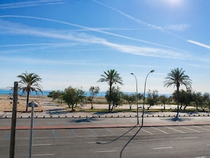 A parking lot with palm trees and a clear sky.