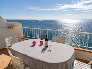 Ein Balkon mit Tisch für zwei Personen, mit Blick auf das Meer.