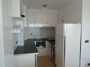 Een koelkast, een oven, een kookplaat, een koffiezetapparaat/waterkoker
