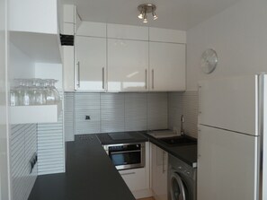 Een koelkast, een oven, een koffiezetapparaat/waterkoker, een waterkoker